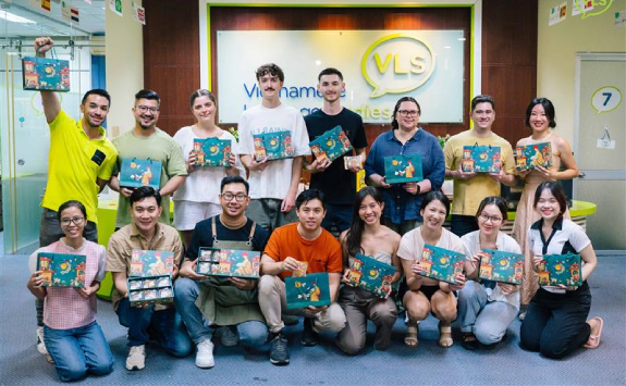 A group of interns in Vietnam pose for a photo holding gift bags